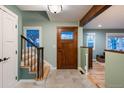 Light-filled entryway with stairs, wood door and soft green walls at 14117 W 58Th Pl, Arvada, CO 80004