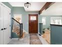 Inviting foyer featuring a decorative glass front door, wooden stairs and custom trim at 14117 W 58Th Pl, Arvada, CO 80004