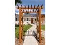 Charming home featuring a landscaped front yard with a wooden pergola over the walkway to the front door at 14117 W 58Th Pl, Arvada, CO 80004