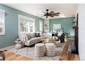 Comfortable living room featuring a large window, stylish furniture and a ceiling fan at 14117 W 58Th Pl, Arvada, CO 80004