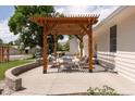 Relaxing outdoor patio with a wooden pergola, seating, and a fire pit, perfect for entertaining at 14117 W 58Th Pl, Arvada, CO 80004