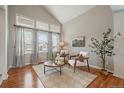Bright living room featuring large windows, vaulted ceilings, and hardwood floors at 5486 S Cathay Way, Centennial, CO 80015