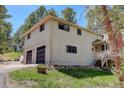 A well-maintained home featuring an attached two-car garage and charming exterior details at 8795 Rudd Rd, Evergreen, CO 80439