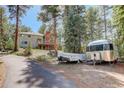 Scenic shot of the home, trailers, and lush surrounding landscape offering a glimpse of the outdoor lifestyle at 8795 Rudd Rd, Evergreen, CO 80439