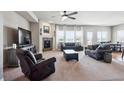 Bright living room with a fireplace, plush seating, and large windows offering scenic views at 6019 S Little River Way, Aurora, CO 80016