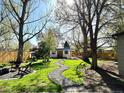 Expansive backyard featuring mature trees, a winding stone path, and a shed at 2200 Teller St, Lakewood, CO 80214