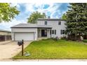 Charming two-story home with a well-maintained lawn and an attached garage at 7431 Webster St, Arvada, CO 80003