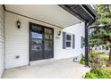 Inviting front porch featuring a black screen door and classic wall sconces at 7431 Webster St, Arvada, CO 80003