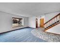 Inviting living room with staircase, a large window, and tiled entryway at 12287 W Aqueduct Dr, Littleton, CO 80127