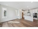 Bright kitchen showcases hardwood floors, modern white cabinetry, stainless steel appliances, and a center island at 1255 Penner Dr, Erie, CO 80026