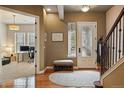 Welcoming foyer with hardwood floors, a bench, and access to a home office space at 7831 Inverness Blvd, Englewood, CO 80112