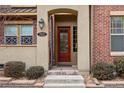 Inviting front entrance features a red door with decorative glass and a covered porch at 7831 Inverness Blvd, Englewood, CO 80112