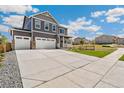 Lovely home showcasing a large driveway, a three-car garage, and picturesque landscaping at 14249 Beebalm Ave, Parker, CO 80134