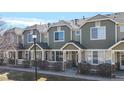 Attractive townhome showcasing a private front patio, lush landscaping, and detailed architectural features at 16047 E Geddes Ln # 128, Aurora, CO 80016