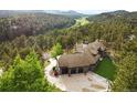 Aerial view showcasing a luxurious home with a three-car garage, surrounded by lush forest and mountain views at 2548 Keystone Dr, Evergreen, CO 80439