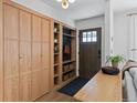 Bright mudroom featuring wood cabinets, built-in storage, and modern fixtures near the front door at 7633 S Gilpin Ct, Centennial, CO 80122