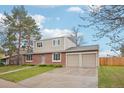 Beautiful home with a two-car garage, complemented by lush greenery and a welcoming entrance at 4623 S Kalispell Way, Aurora, CO 80015