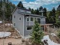 Gray two-story home featuring a modern design and complemented by the surrounding trees at 31932 Steven Way, Conifer, CO 80433