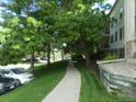 Exterior shot of a community sidewalk surrounded by mature trees and manicured landscaping, offering a serene environment at 6705 S Field St # 802, Littleton, CO 80128