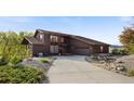 Charming two-story brown home with a concrete driveway and beautiful landscaping at 3900 Bogey Ct, Longmont, CO 80503
