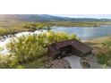 Gorgeous home with a lake view, beautiful brown siding, and a lovely tree line at 3900 Bogey Ct, Longmont, CO 80503