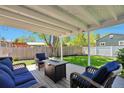 Inviting covered deck with comfortable seating and a fire pit, perfect for outdoor relaxation at 6179 S Bemis St, Littleton, CO 80120