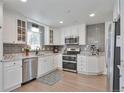Modern kitchen featuring white cabinets, stainless steel appliances, and granite countertops at 6179 S Bemis St, Littleton, CO 80120