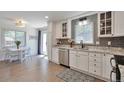 Bright eat-in kitchen with white cabinetry, stainless steel appliances, and stylish backsplash at 6179 S Bemis St, Littleton, CO 80120