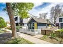 A charming home featuring a yellow front door and a lovely white fence, perfect curb appeal at 444 Inca St, Denver, CO 80204