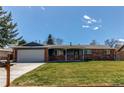 Attractive single-story home with a well-kept lawn, a brick facade, and a spacious driveway at 9880 W 76Th Pl, Arvada, CO 80005