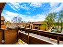 Balcony view overlooks exterior of brown buildings and parking area with blue skies above at 7080 W 20Th Ave # 202, Lakewood, CO 80214