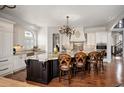 Spacious kitchen featuring a large island with seating, custom cabinetry, and hardwood floors at 2117 S Juniper St, Lakewood, CO 80228