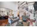 Elegant living room with soaring ceilings, hardwood floors, iron staircase, and refined finishes at 2117 S Juniper St, Lakewood, CO 80228
