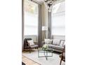 Sunlit living room featuring modern lighting fixture, neutral-colored furnishings, and large windows with curtains at 619 S High St, Denver, CO 80209