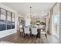 Elegant dining room featuring hardwood floors, modern chandelier, and seamless flow to the kitchen at 6519 14Th St, Frederick, CO 80530