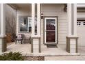 Inviting front porch with seating area, decorative columns, and a stylish entryway at 3596 S Jebel Cir, Aurora, CO 80013