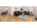 Bright living room with hardwood floors, leather couches, and large windows allowing natural light to stream in at 1380 S Fillmore St, Denver, CO 80210
