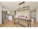 A modern, open-concept kitchen and dining area with statement lighting at 15545 Lipan St, Broomfield, CO 80023