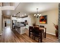 Open concept kitchen with island, stainless steel appliances, and hardwood floors at 9711 W Indore Dr, Littleton, CO 80128