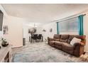 Open-concept living room and dining area featuring wood-look flooring and natural light at 7695 E Quincy Ave # 105, Denver, CO 80237