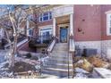 Townhouse entry with steps leading to the front door and a small patio area at 2 Garfield St # B, Denver, CO 80206