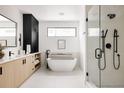 Bright bathroom features a modern tub, frameless glass shower and sleek vanity at 5392 Lions Paw St, Castle Rock, CO 80104