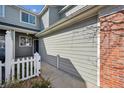 The exterior of this townhome shows the siding and brick detailing around the garage at 12860 E Dickensen Pl, Aurora, CO 80014