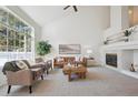 Spacious living room with vaulted ceilings, fireplace, and large windows at 12860 E Dickensen Pl, Aurora, CO 80014