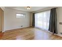 Bright living room features hardwood floors, large window with curtains, and fresh paint at 11085 Clarkson St, Northglenn, CO 80233