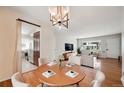 Dining area with a modern light fixture, hardwood floors, and views of the living room and kitchen at 2777 S Adams St, Denver, CO 80210