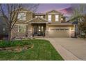 Charming two-story home with a stone and siding exterior, a well-manicured lawn, and a two-car garage at 2349 Hickory Pl, Erie, CO 80516