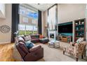 Grand living room with high ceilings, large windows, and a cozy fireplace at 2349 Hickory Pl, Erie, CO 80516