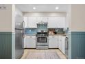 Well-lit kitchen with stainless steel appliances, white cabinetry, and blue backsplash at 8773 W Cornell Ave # 10, Lakewood, CO 80227