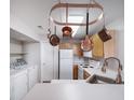 Practical kitchen, adjacent to laundry space, features a sink and pot rack at 8621 E Dry Creek Rd # 325, Englewood, CO 80112